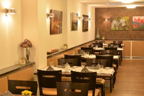 uma sala de jantar com mesas e cadeiras num restaurante em Linden's Pension-Restaurant em Ayl