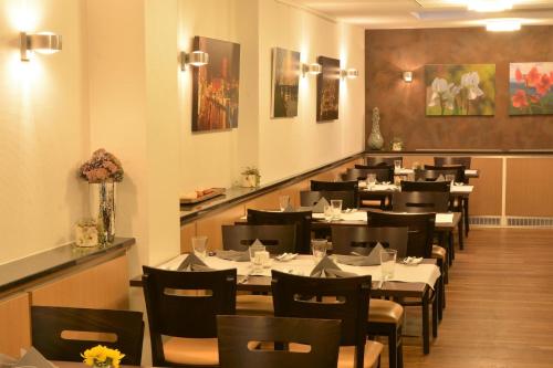 a dining room with tables and chairs in a restaurant at Linden's Pension-Restaurant in Ayl