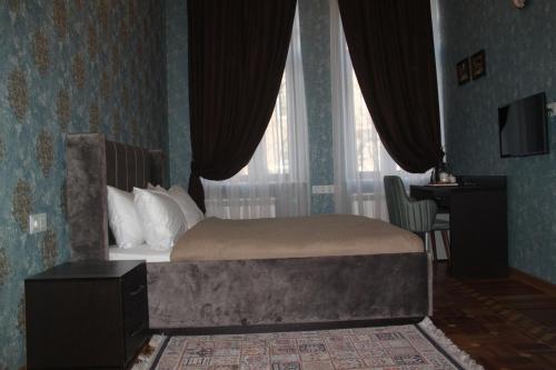 a bedroom with a bed with a large window at Hotel 1883 in Baku