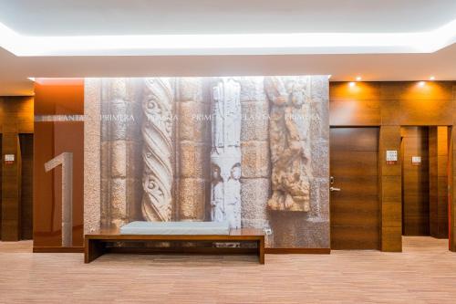 Hotel Compostela في سانتياغو دي كومبوستيلا: لوبي به لوحة كبيرة على الحائط