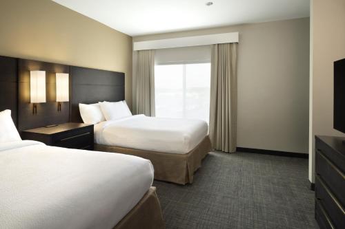 a hotel room with two beds and a television at Residence Inn by Marriott Jonesboro in Jonesboro