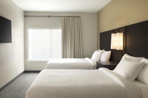 a hotel room with two beds and a window at Residence Inn by Marriott Jonesboro in Jonesboro