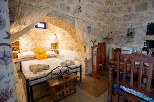 a bedroom with a bed in a stone wall at Trullo Tranquillo in San Michele Salentino