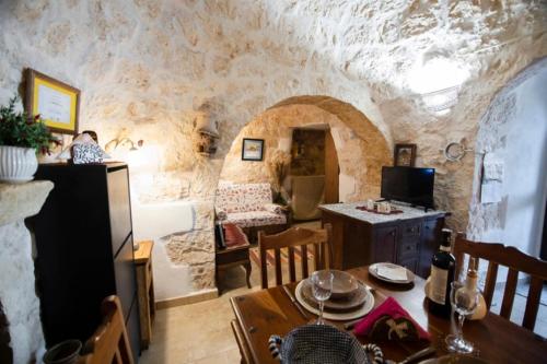 a kitchen and dining room with a stone wall at Trullo Tranquillo in San Michele Salentino