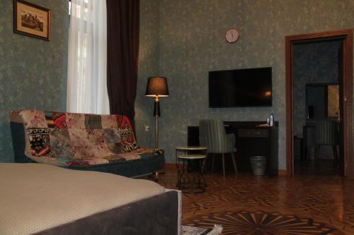 a bedroom with a bed and a chair and a television at Hotel 1883 in Baku