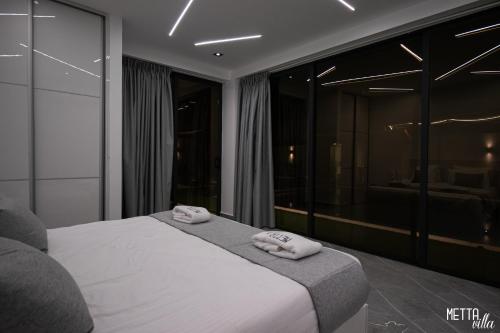 een slaapkamer met een bed met twee handdoeken erop bij Metta Villa in Al Rama