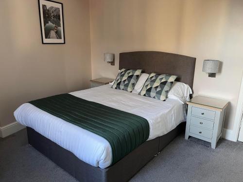 a bedroom with a large bed and a night stand at Geminian in Harrogate