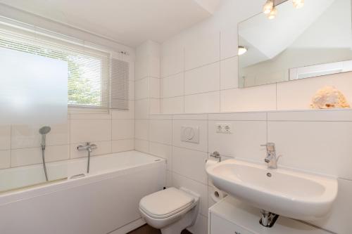 een witte badkamer met een wastafel en een toilet bij Ferienwohnung W16 3 S in Graal-Müritz