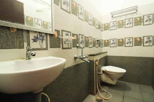 a bathroom with a sink and a toilet at Bouvana Residency in Puducherry