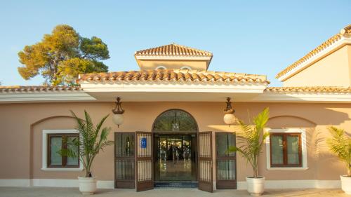 una entrada a un edificio con palmeras delante en Hotel Montepiedra 4''''sup en Playas de Orihuela