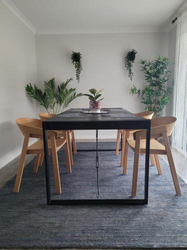 a black table with chairs and plants in a room at New apartment 3 min to Sovereign Hill & Wildlife Park in Ballarat