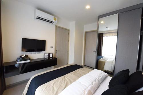 a bedroom with a large bed and a television at Super Luxury Condo in Bangkok