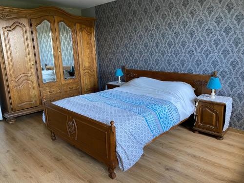 ein Schlafzimmer mit einem Bett mit einer Kommode und einem Spiegel in der Unterkunft Quiétude à la ferme in Houdremont