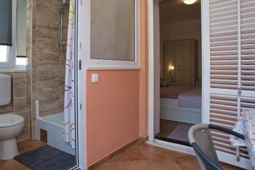 a small bathroom with a toilet and a bedroom at Apartment Ella in Trogir