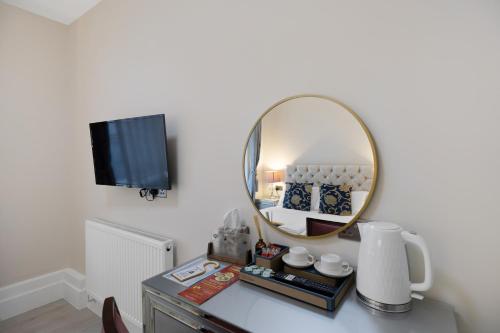 a mirror on top of a dresser in a room at Drake Hotel Plymouth in Plymouth