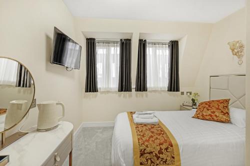 a bedroom with a bed and a sink and a mirror at Drake Hotel Plymouth in Plymouth