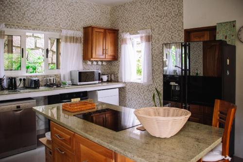 a kitchen with a counter top and a refrigerator at SOUTH HILL VILLA in Mahe