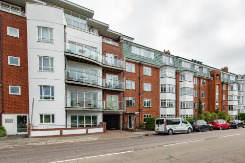 an apartment building with cars parked in front of it at Solent Court in Portsmouth