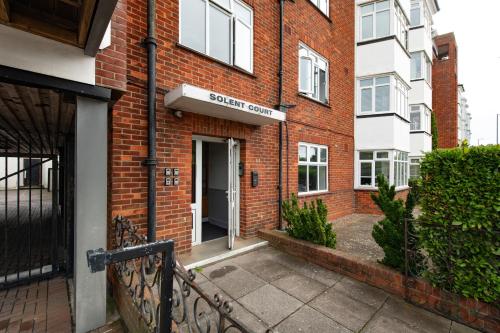 a door to a brick building with a sign on it at Solent Court in Portsmouth