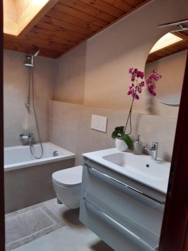 ein Badezimmer mit einem Waschbecken, einem WC und einer Badewanne in der Unterkunft Casa Gina in Roana