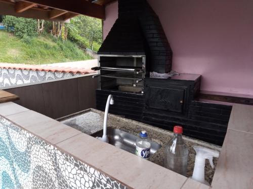 a kitchen with a sink and an outdoor oven at lugar do descanso in Juqueri-Mirim
