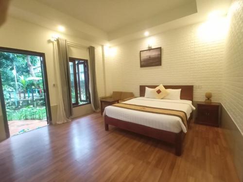 een slaapkamer met een bed en een groot raam bij GREENSPACE RESORT PHUQUOC in Phu Quoc