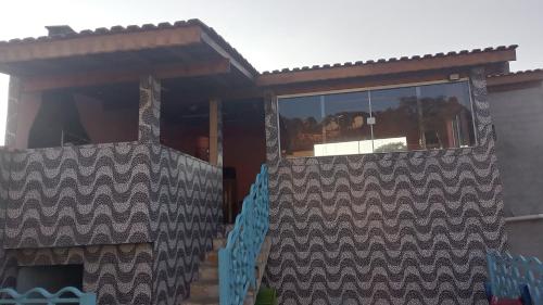 a house with a screened in porch with a window at lugar do descanso in Juqueri-Mirim