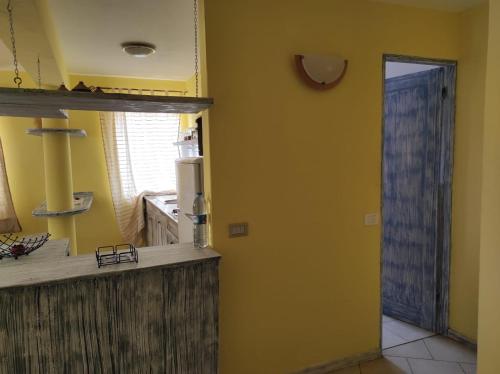 a kitchen with a yellow wall and a door to a kitchen at Casa Laranja Santa Maria in Santa Maria