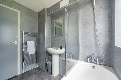 a bathroom with a sink and a bath tub and a sink at *F6GH For your most relaxed & cosy stay + FREE PARKING & WiFi in Bramley