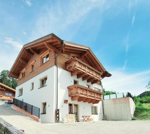 a house with a wooden balcony on top of it at Schickster Mountain Lodge in Unterweidach