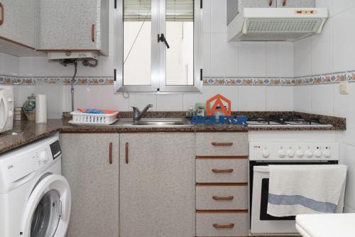 a kitchen with a sink and a washing machine at Solimar, 4-8 in Cullera