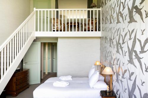 a room with a bed and a staircase at Le Relais Saint Michel in Le Mont Saint Michel