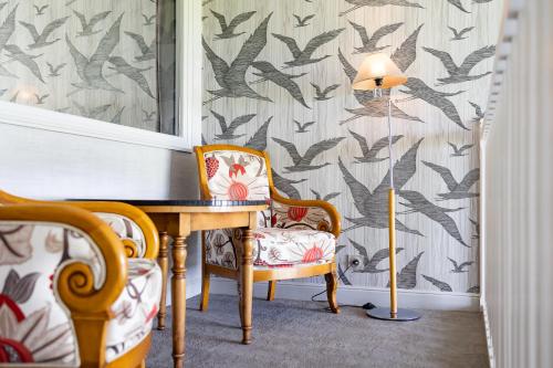 a table and two chairs and a lamp in a room at Le Relais Saint Michel in Le Mont Saint Michel