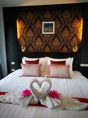 a bed with two swans in the shape of a heart at Elephant Room in Patong Beach