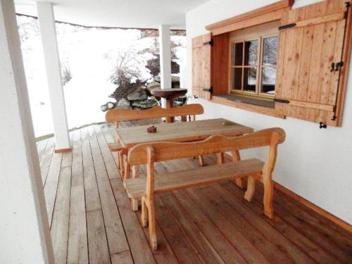 een veranda met een tafel en banken op een terras bij Chalet Mund in Mund