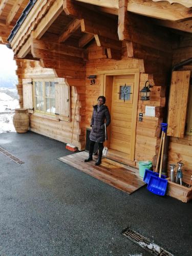 a man standing in the doorway of a log cabin at Chalet Mund in Mund