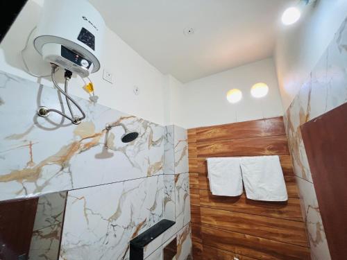 a bathroom with a shower and a camera on the wall at Home Escape Luxé Private Villa- Indralaya in Ujjain