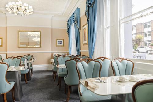 a dining room with chairs and tables and a window at The Drake Hotel Plymouth in Plymouth