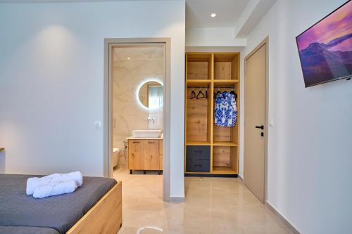 a bedroom with a bed and a bathroom with a sink at Polgar Villas Corfu in Kavvadádes