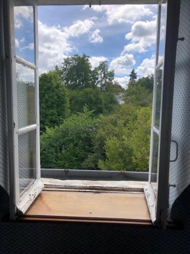 an open window with a view of trees at TourTour Guest Room in Saint-Avertin