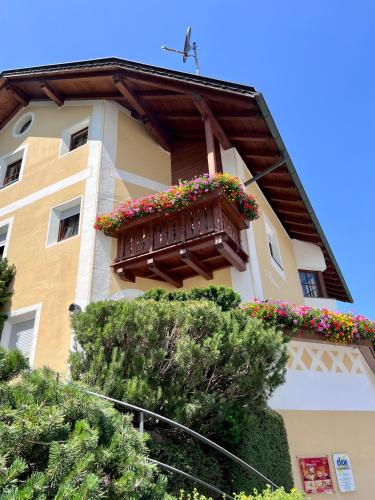 a building with a balcony with flowers on it at Apartments Mauriz in Selva di Val Gardena