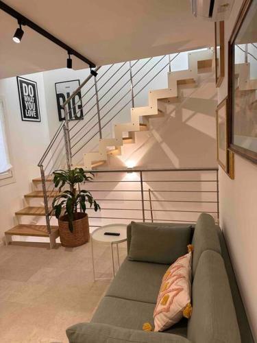 a living room with a couch and a staircase at David Design Apartment centro storico in Caorle