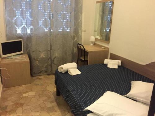 a small bedroom with a bed and a television at HOTEL BISSI in Milan