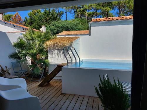 un patio avec une piscine sur une terrasse dans l'établissement LOCATIONS NOS ILES, à Saint-Jean-de-Monts