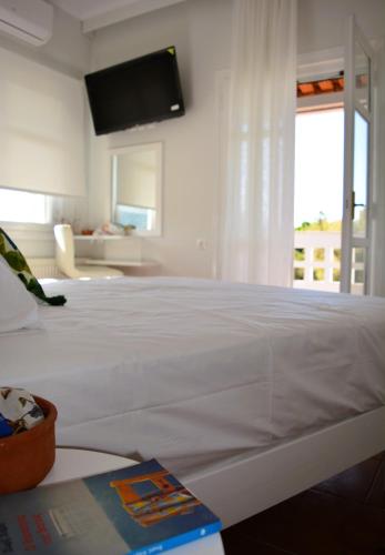 a white bed in a room with a window at Tarmaros - Families & Groups in Sissi