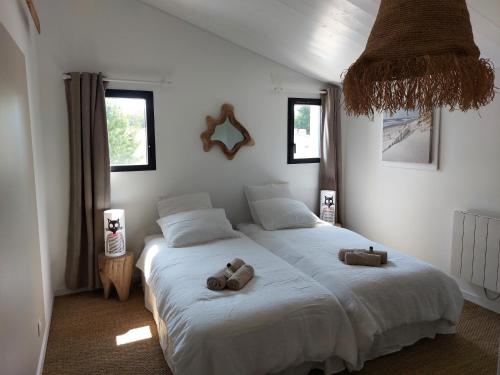 une chambre avec un lit avec deux ours en peluche dessus dans l'établissement LOCATIONS NOS ILES, à Saint-Jean-de-Monts