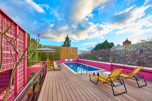 a deck with chairs and a swimming pool on a building at City Centro by Marriott Oaxaca in Oaxaca City