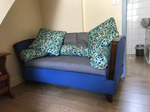 a blue couch with pillows on it in a room at Simone's Tiny House in Montpellier