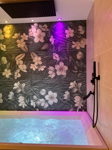 a bathroom with a bath tub with a flower wallpaper at Il Gelsomino luxury suites in Bari