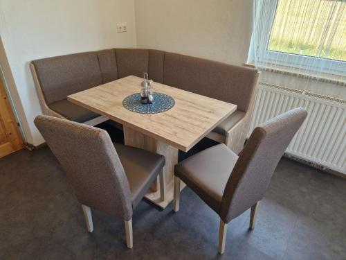 einem Holztisch mit Stühlen, einem Tisch und einem Tisch mit Chairsuggest in der Unterkunft Ferienwohnung BeLu in Velden am Wörthersee